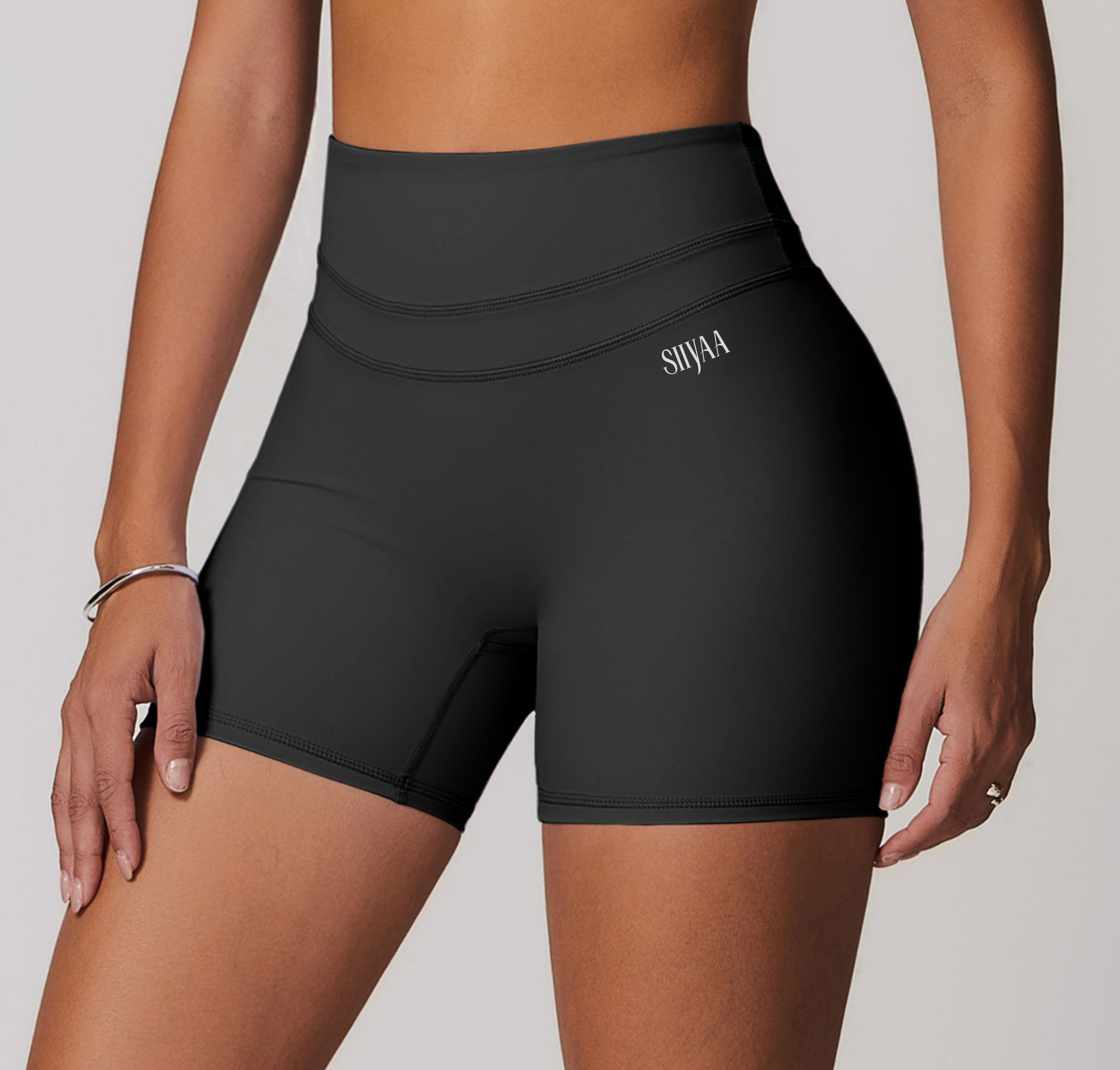 Black athletic shorts worn by a person on a light gray background