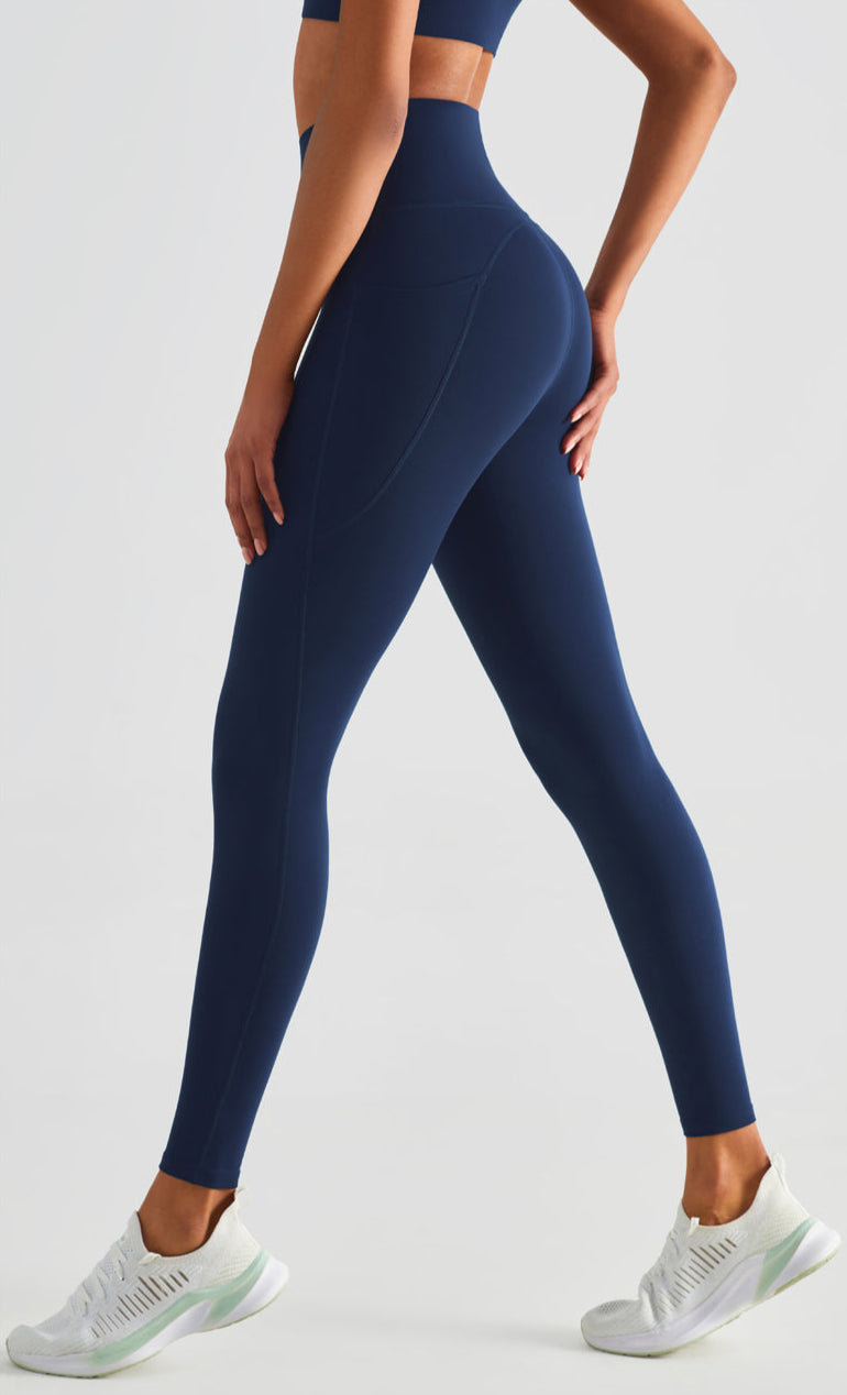 Person wearing navy blue leggings on a light gray background