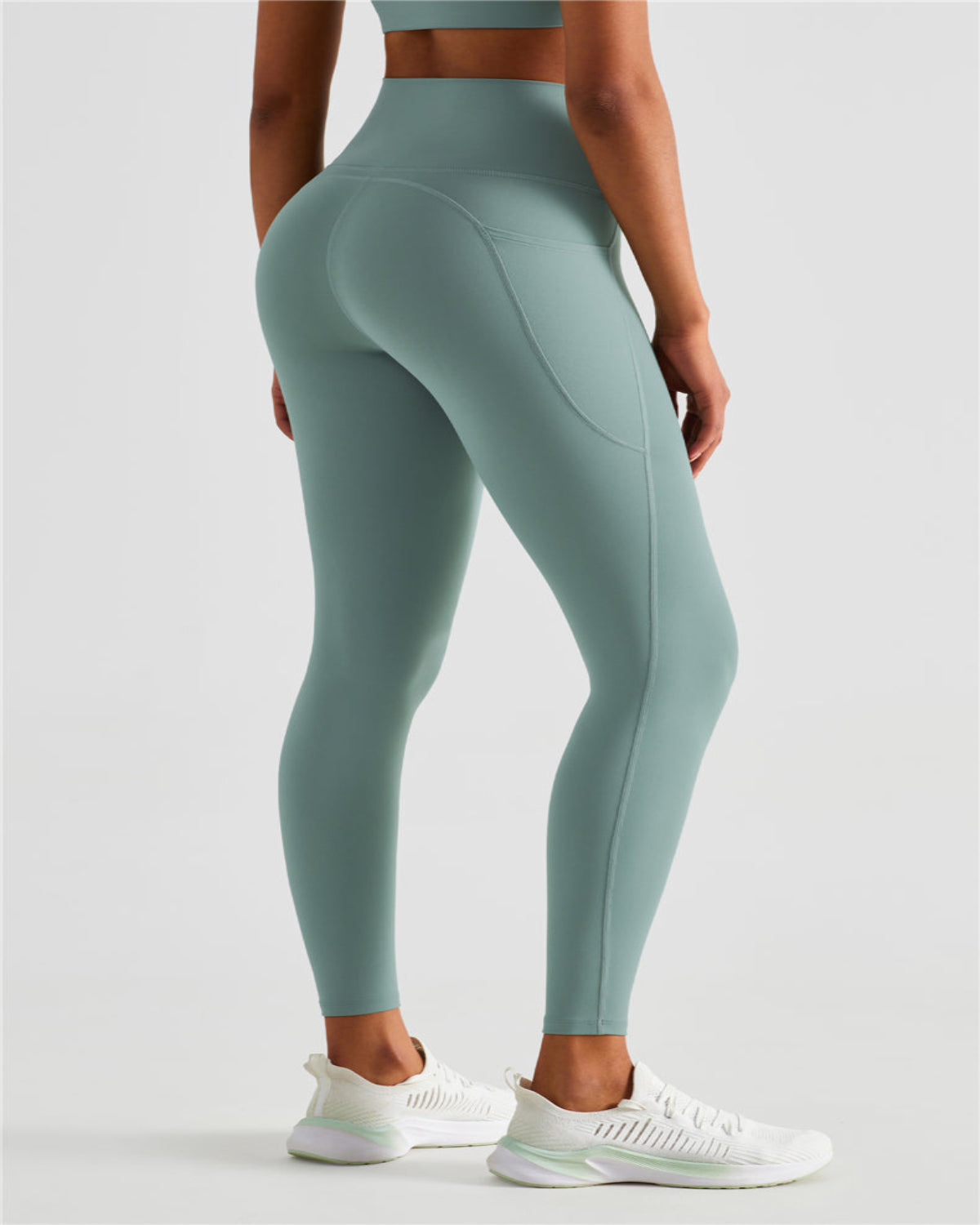 Person wearing teal leggings on a light gray background