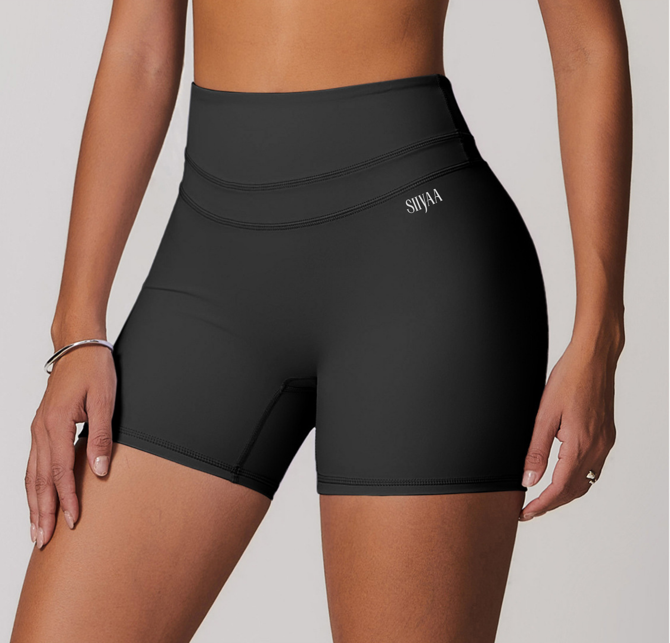 Black athletic shorts worn by a person on a white background