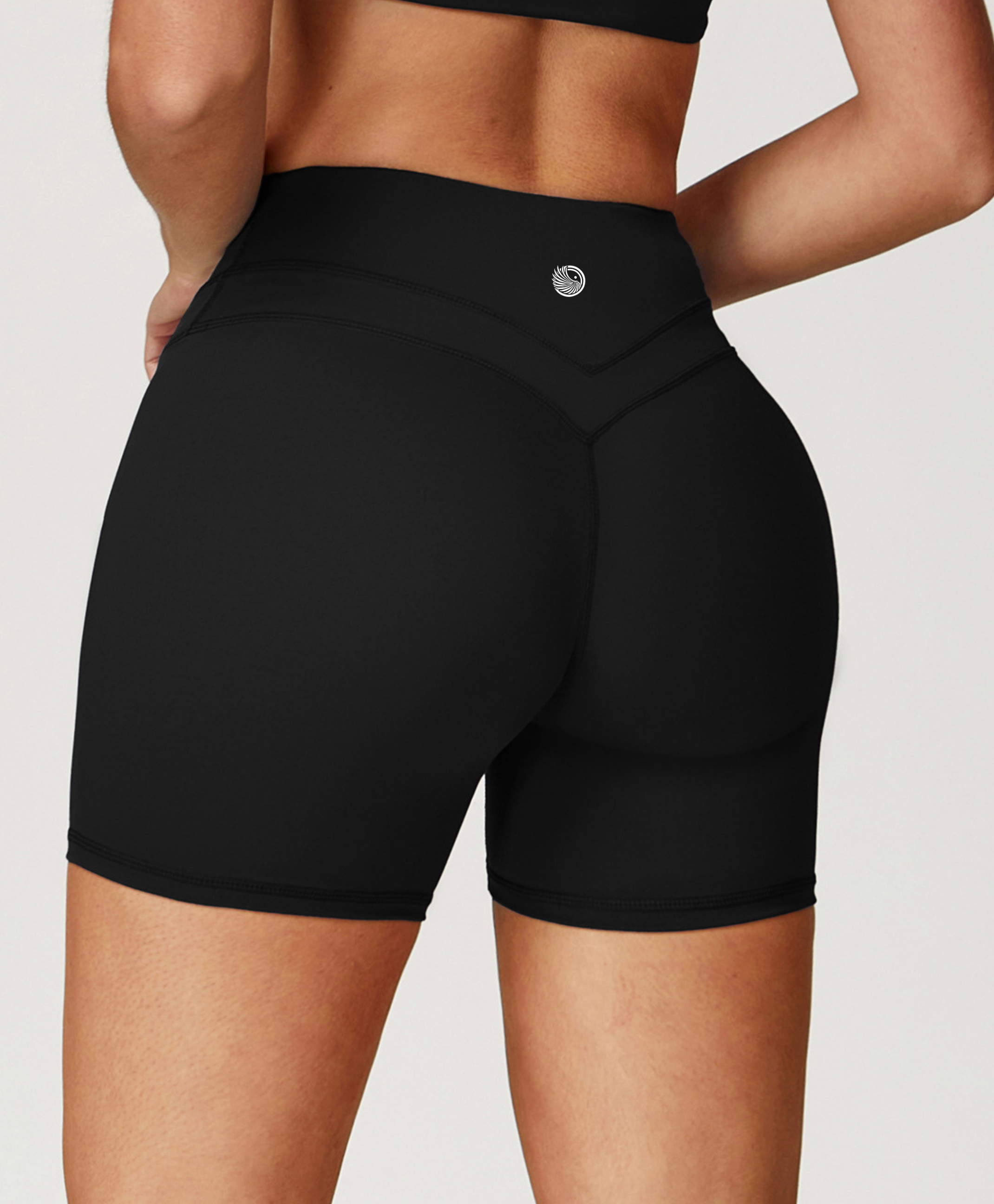 Black high-waisted shorts worn by a person on a white background