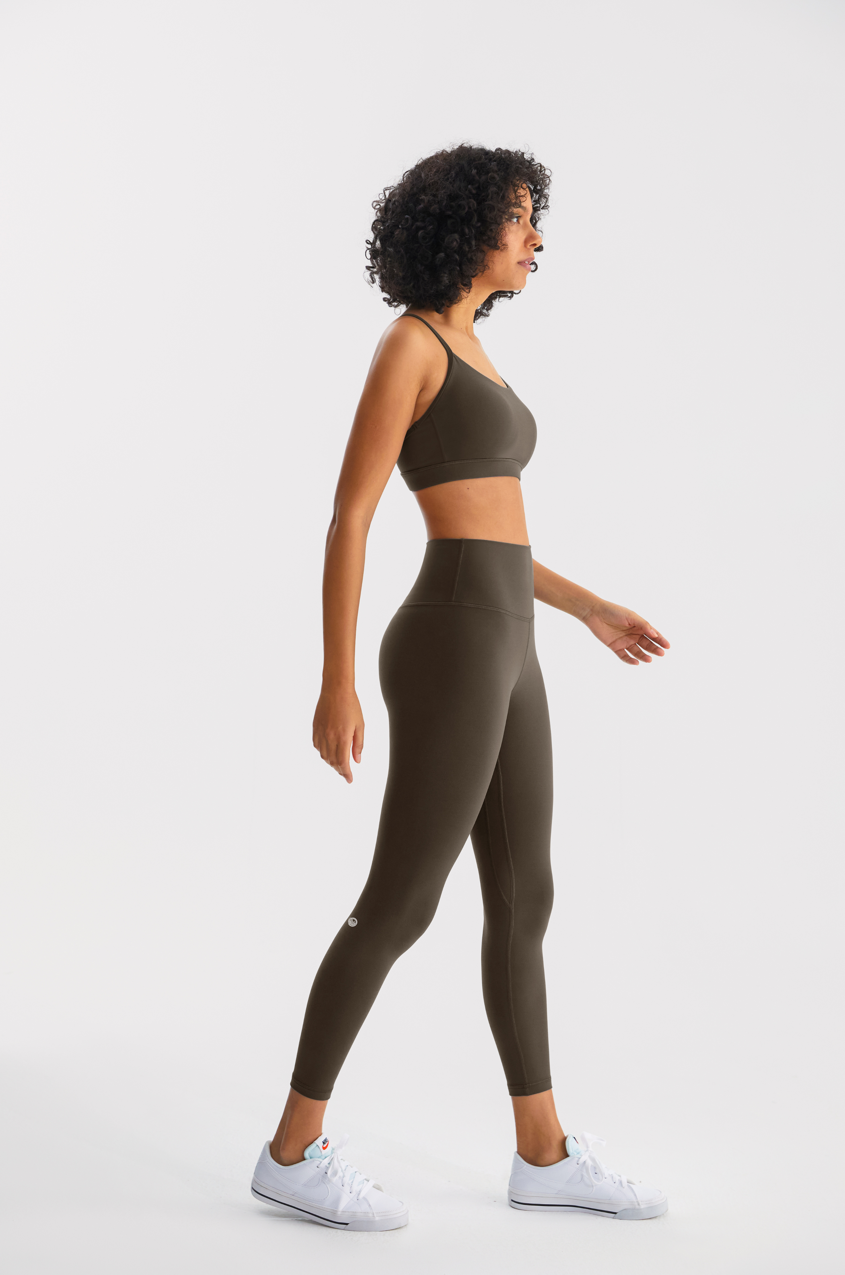 Woman wearing a green athletic outfit on a white background