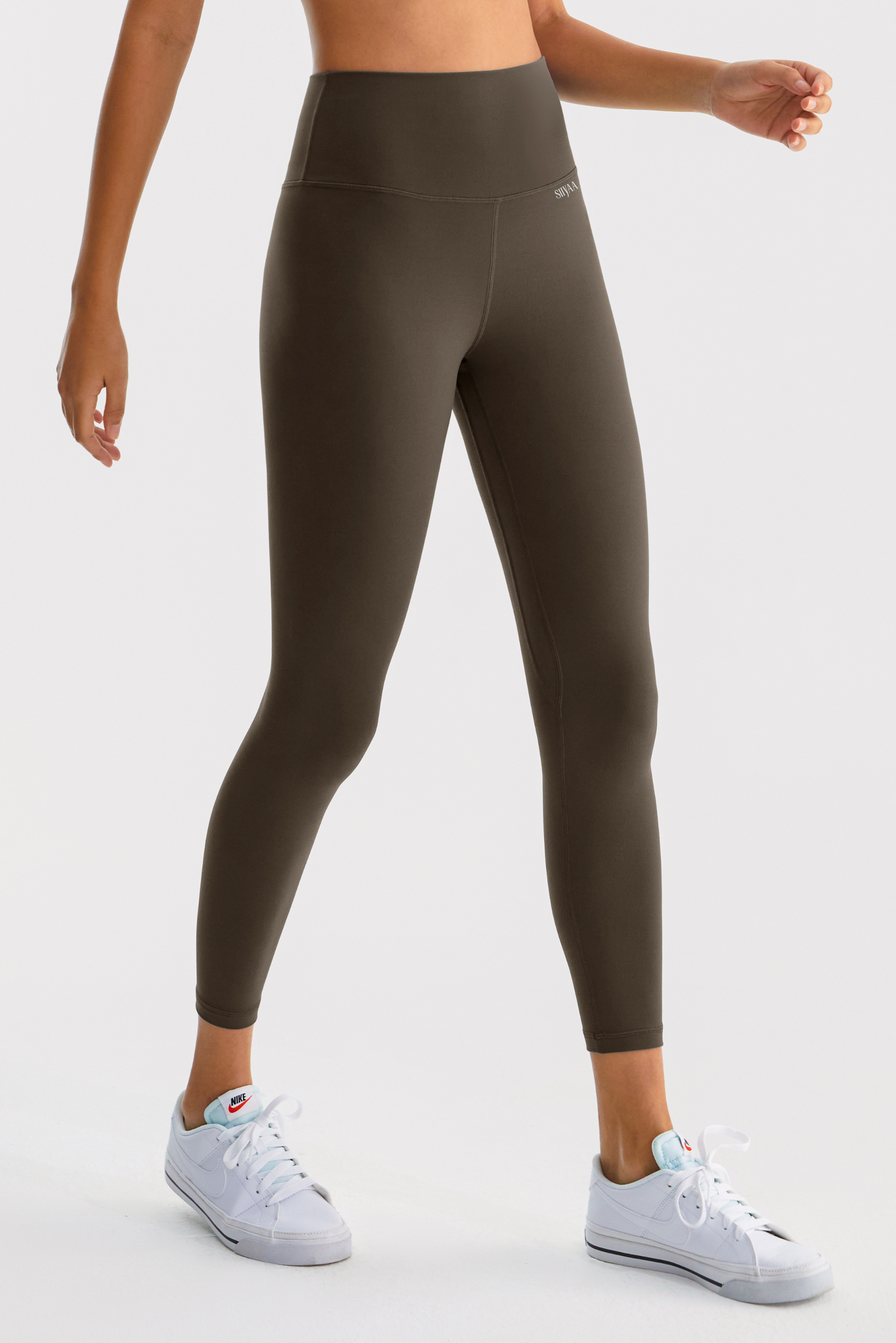 Woman wearing a green athletic outfit on a white background