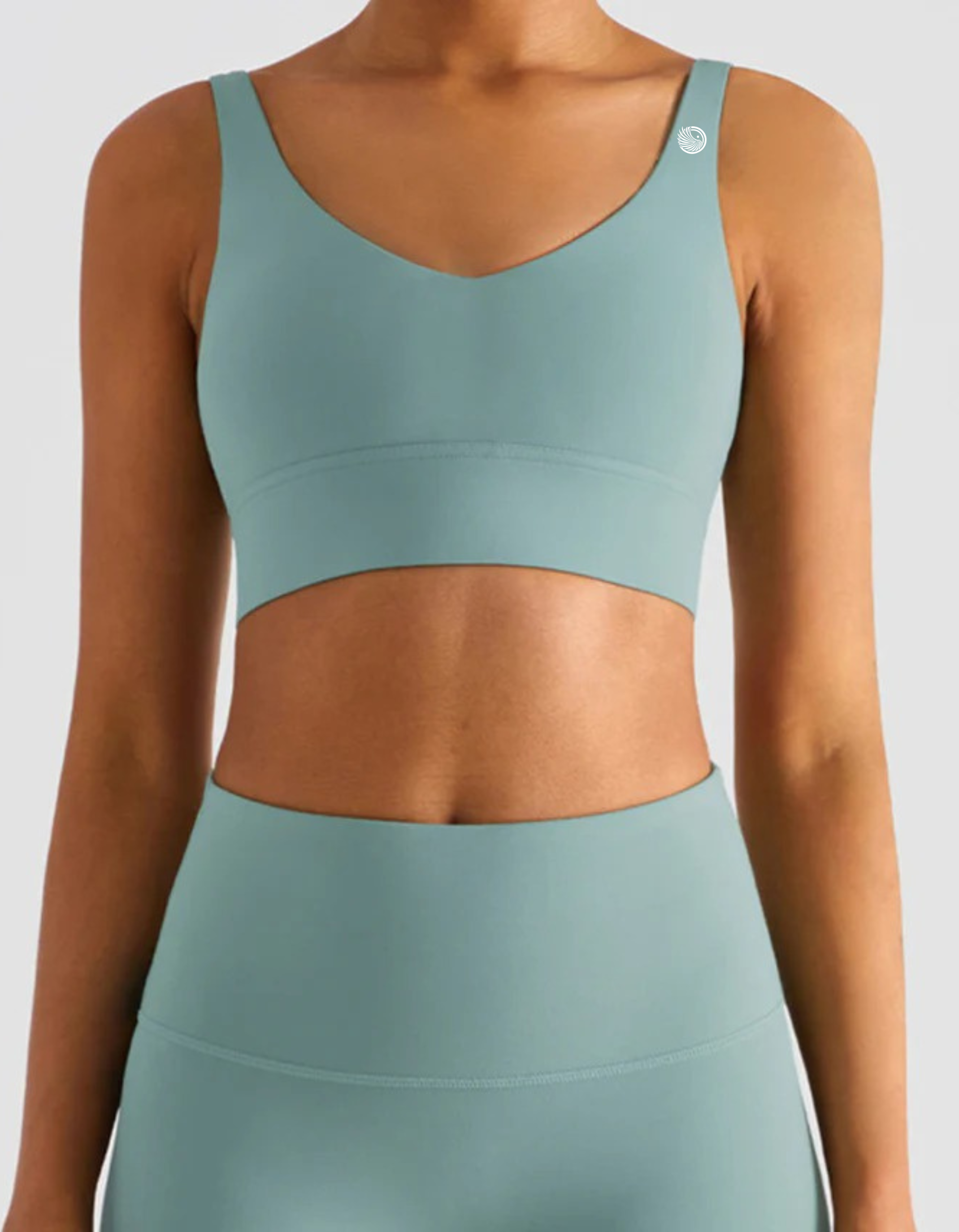 Teal sports bra and leggings set on a plain background