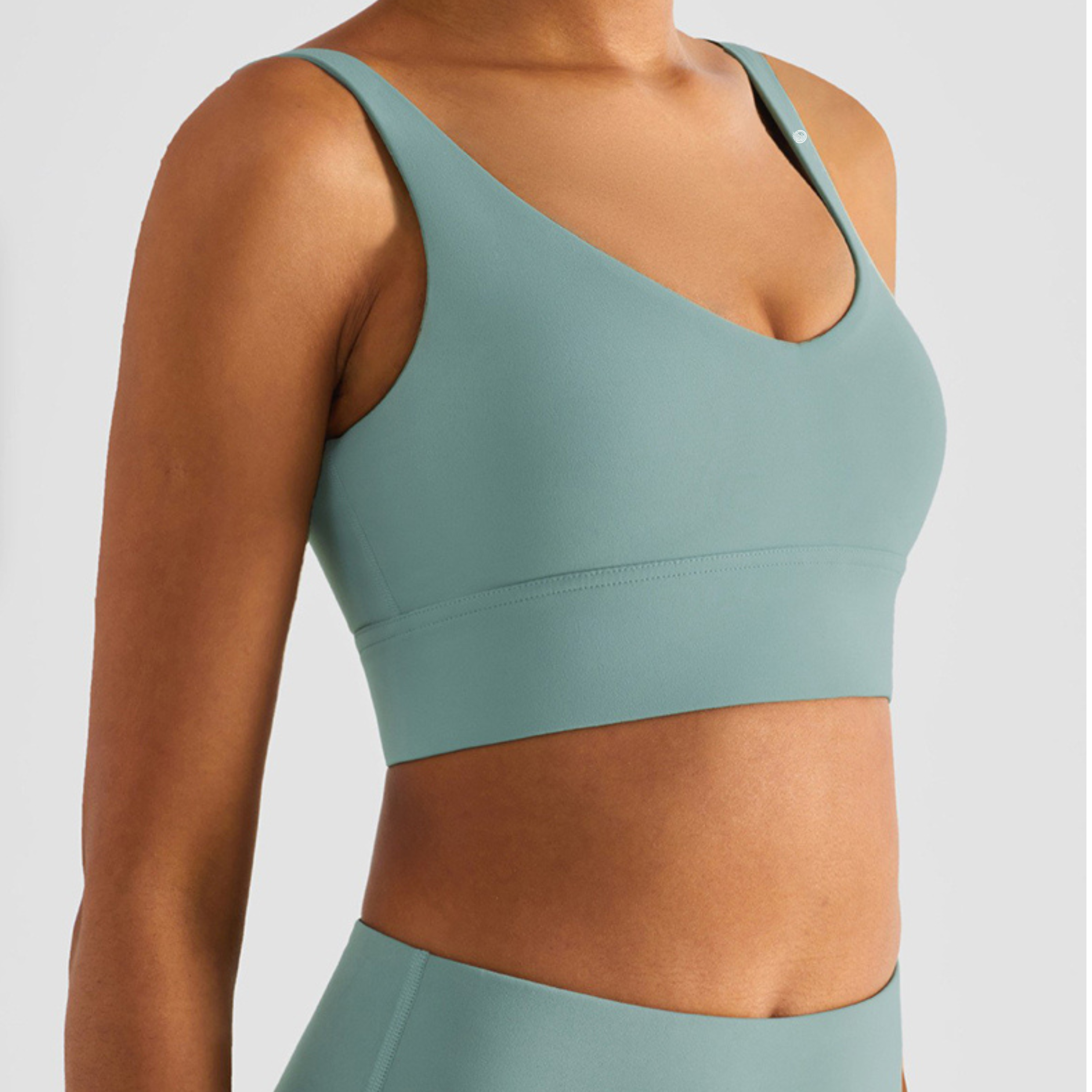 Green sports bra and leggings on a plain background