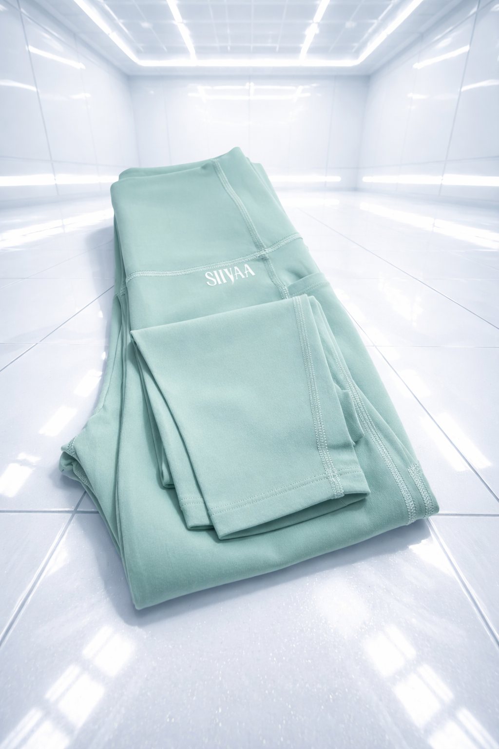 Folded light green towel with 'SIIYAA' branding on a white background