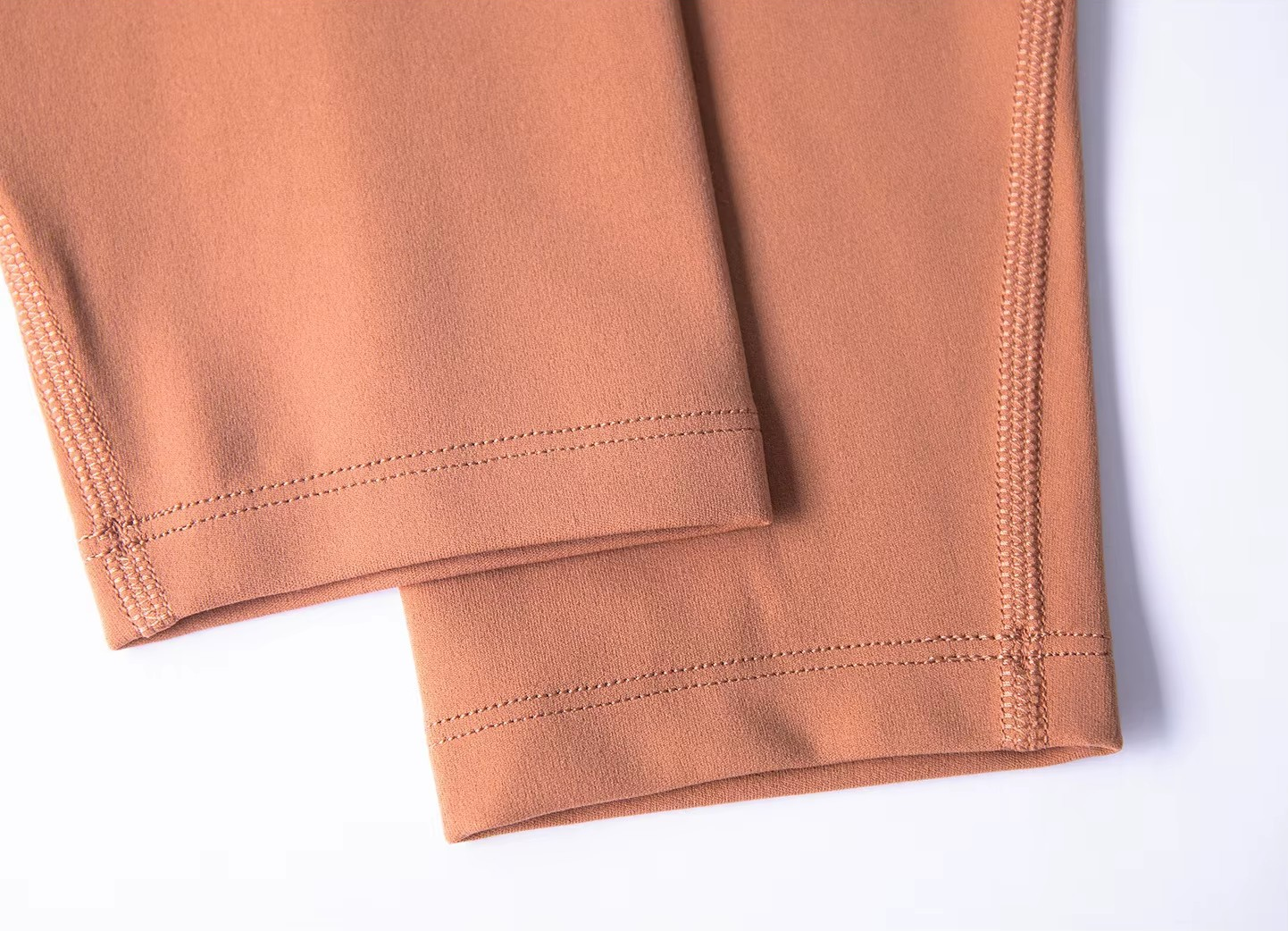 Close-up of a folded peach-colored fabric on a white background
