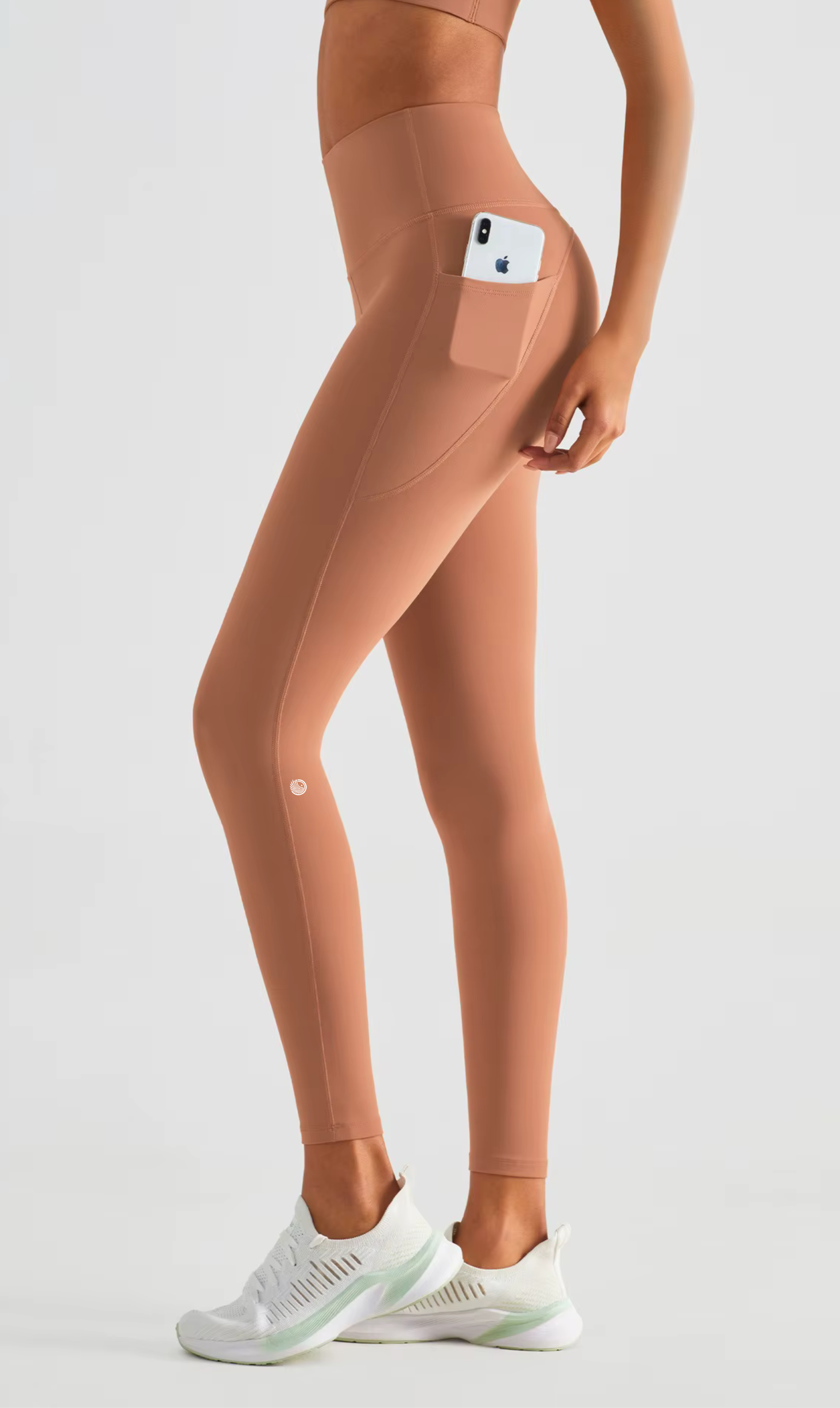 Person wearing peach-colored leggings with a pocket on a white background