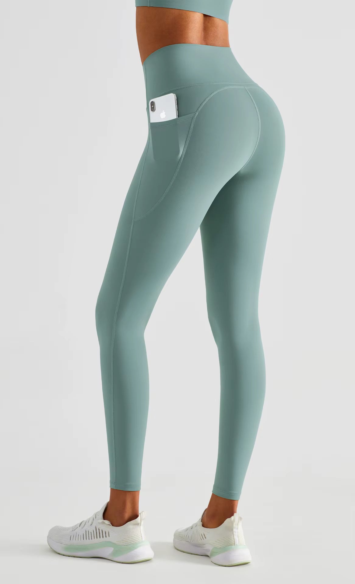 Teal leggings with a pocket on a white background